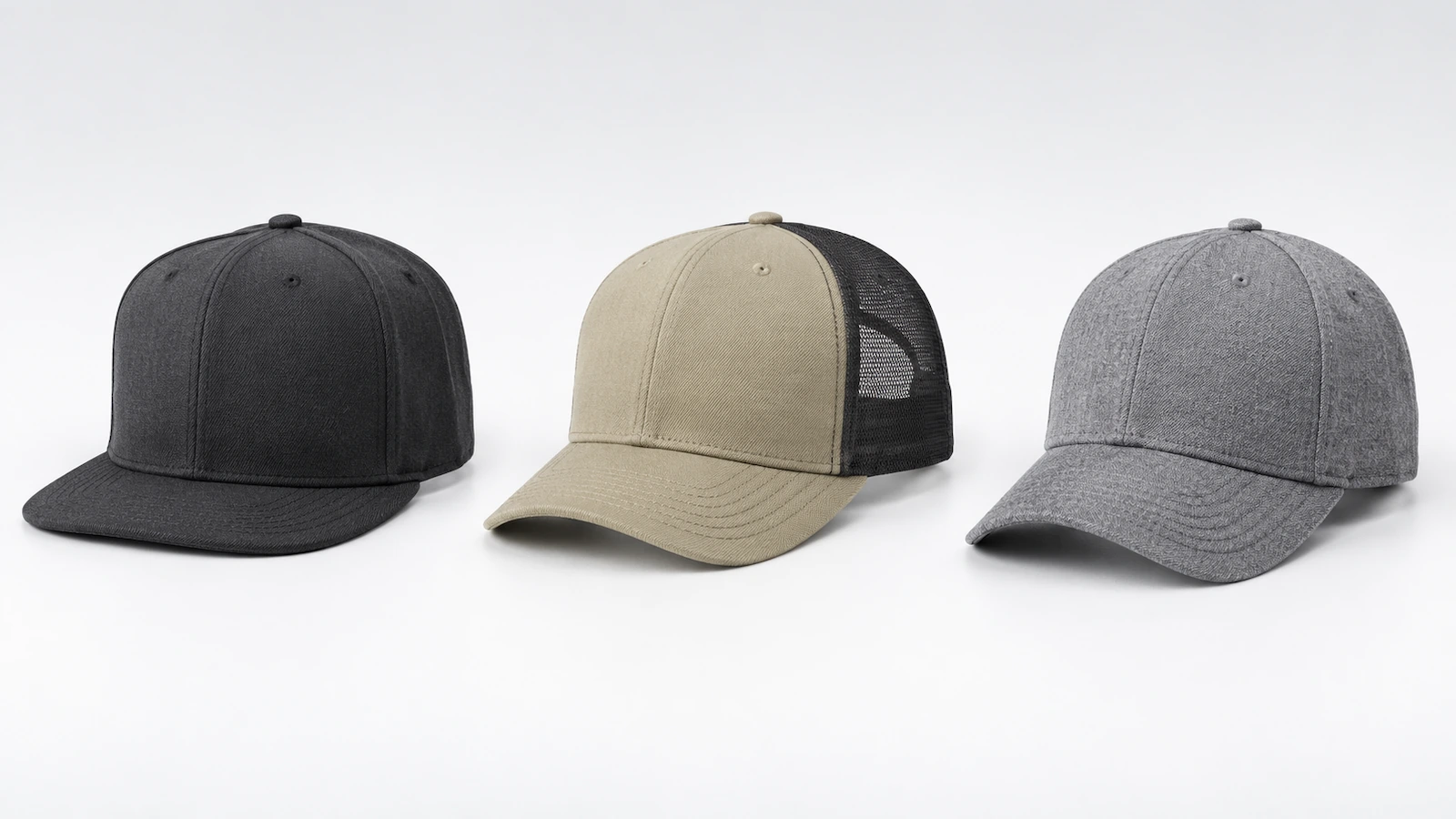 Three plain caps side by side: a high-crown flat-visor fitted cap, a mid-profile mesh-back trucker cap, and a structured six-panel cap without any branding