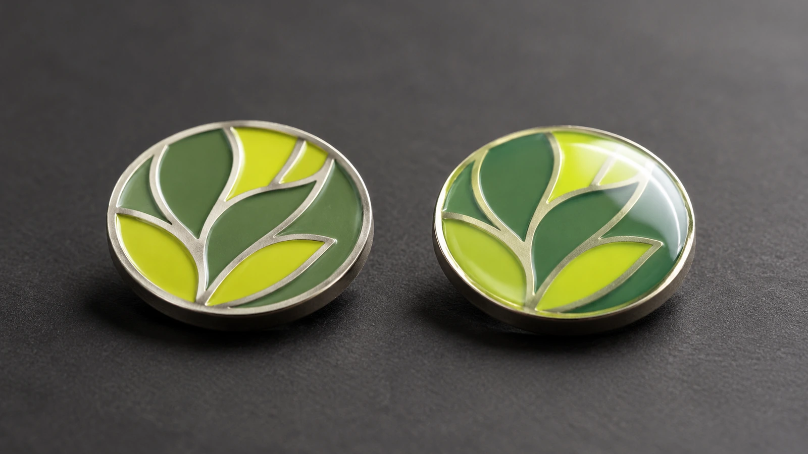 Macro side view of two soft enamel pins, one with textured raised metal lines and one sealed under a glossy clear epoxy dome