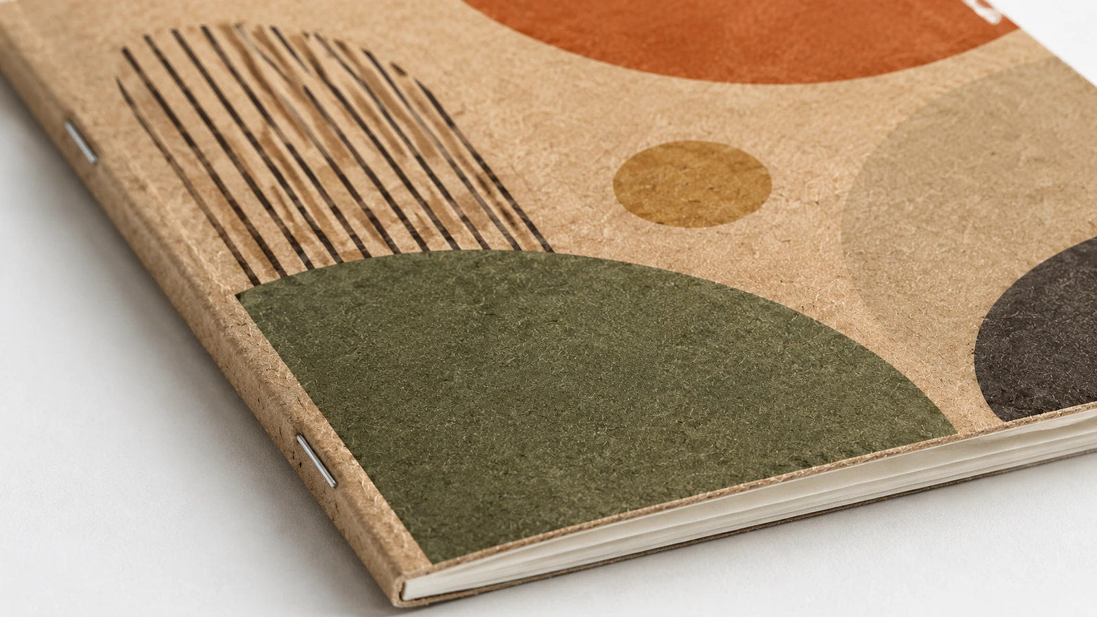 Illustrative kraft cover surface samples beside a plain notebook back cover and saddle-stitched fold